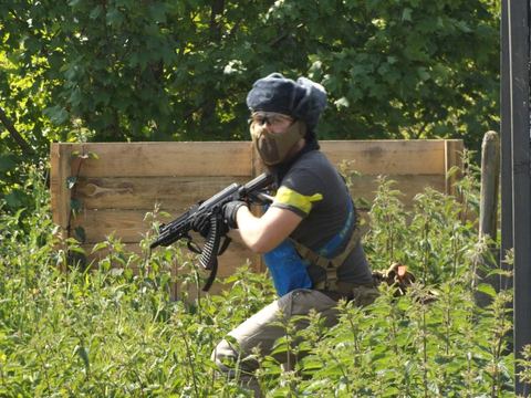 A player crouched by a wooden barricade