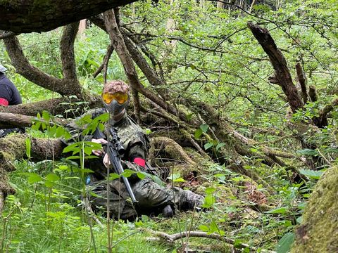 A player in cover under fallen branches