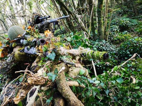Sniper in ghillie suit in the undergrowth
