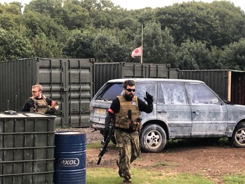 A player by the Range Rover and containers