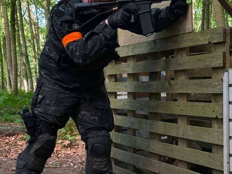 Player aiming from cover beside a wooden structure