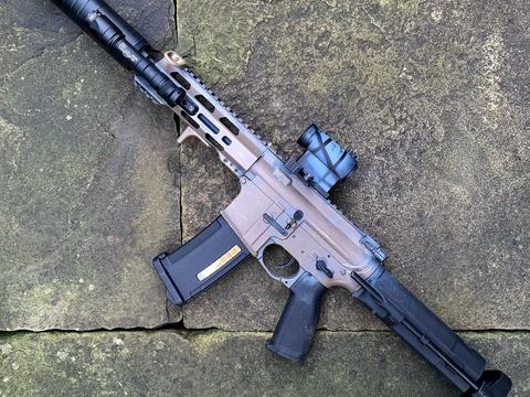 Finished short-barrelled AEG build with red dot, photographed outdoors