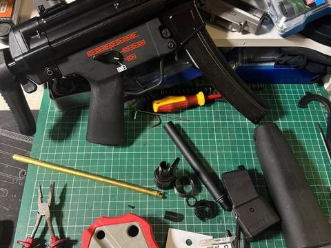 MP5-style AEG on the bench with tools during a service