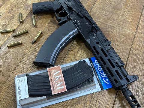 A gas blowback rifle and magazine on the shop's wooden counter