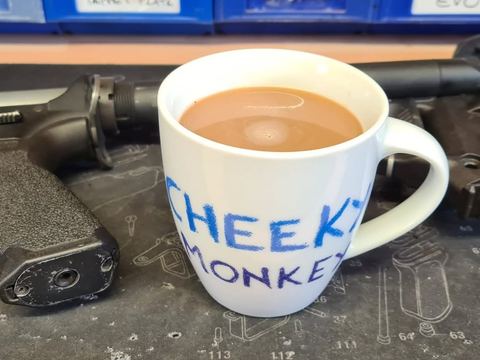 Pistol on the workbench beside the Cheeky Monkey mug