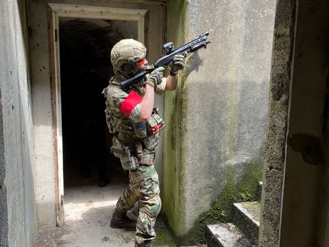 A player at an old bunker doorway during a skirmish