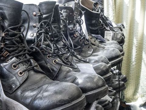 Used surplus combat boots lined up on the shop floor