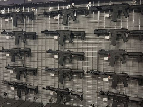 Display wall of rifles above stacked cases