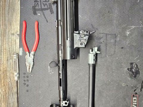 Stripped-down rifle parts on the workshop mat