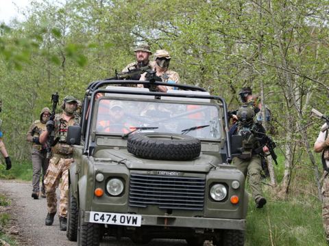 Players riding a Land Rover along the woodland track
