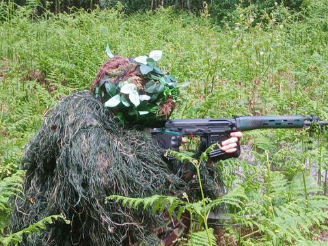 Ghillie-suited player in the ferns at The Fort